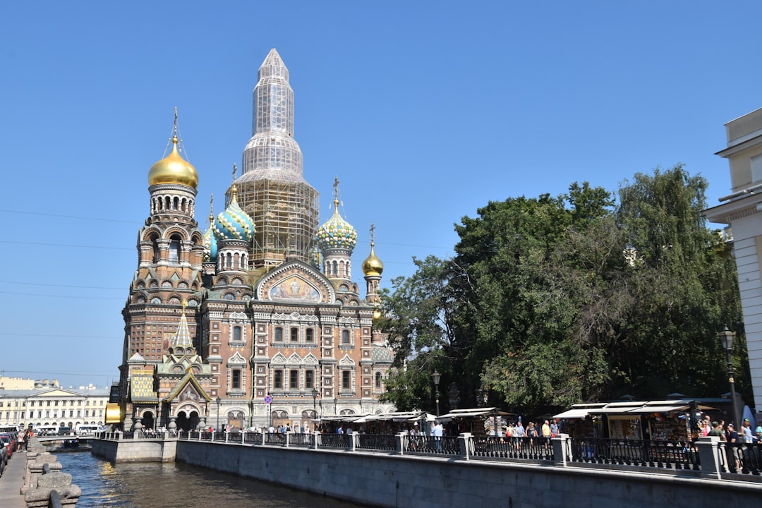 a large building with a golden dome next to a body of water